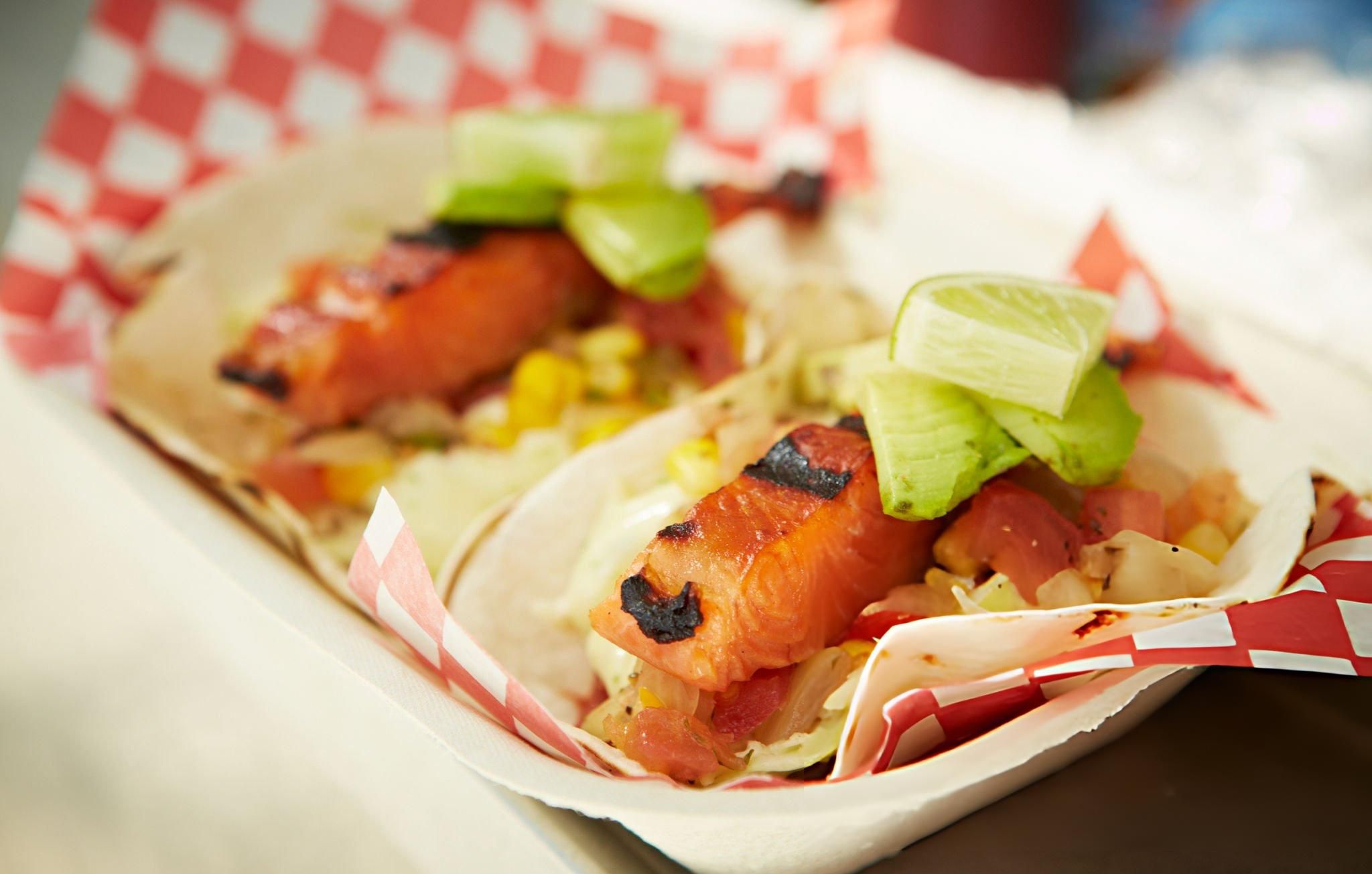 Two salmon tacos for takeout in food truck window in Vancouver